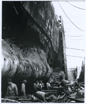 Crew members during a salvage and repair operation work port side of the battered battleship. The U.S.S. West Virginia was hit by seven torpedoes and two bombs during the December 7th attack. 