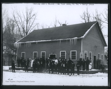 A group of men are pictured outside the building on a snowy day.  Several of the men hold rifles and other firearms.