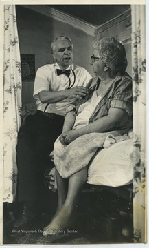 Harriman sits with an unidentified female patient. 