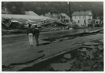 Two people observe the damage around them. 