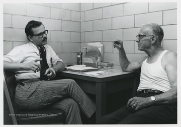 Dr. Weisser, left, sits at a desk with his former instructor.