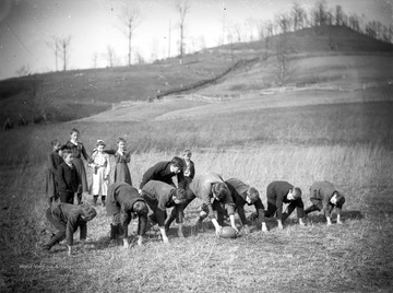A group of boys play football while their classmates watch from behind. The school was a one room school located on the Post family farm in Harrison County, W. Va.