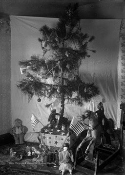Gifts clutter the ground beneath a small Christmas Tree at the home of photographer James Edwin Green.