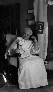 Mary Rupert Green (b. 1854, d. 1929/03/01) was married to Thomas B. Green and mother to photographer James Edwin Green, Sr.  A pennant for the U.S. Marines is hanging in the background.