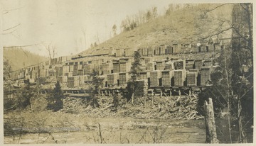 Stacks of lumber are spread across a hill.This photograph is found in a scrapbook documenting the survey for the Baltimore and Ohio Railroad in West Virginia and surrounding states. 