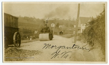 A steamroller participates in early road construction.