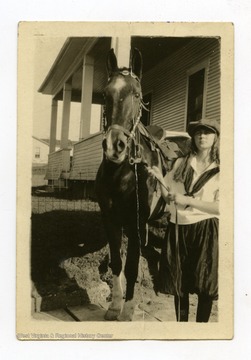Back of Photo Reads: "Katie and their horse up at Bradford's in the yard."