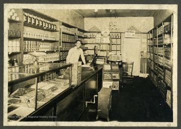 A view of the interior of a grocery store. The clerk may be Rush Holt Sr., an alumnus of WVU and later a senator. 