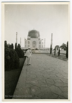 A view of the Taj Mahal, showing wartime air raid protection measures on the central dome. The man is likely Louis Johnson.