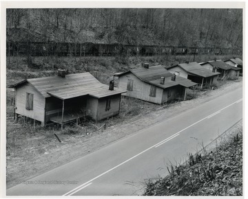 "Empty coal cars and boarded-up and abandoned houses symbolize the idleness that has come upon this community following a decrease in coal production in the area. Other parts of the country are also affected by high unemployment. President Kennedy's Executive Order Number 1, calling for stepped-up distribution of abundant agricultural commodities, will aid areas of pressing need such as this." USDA Office of Information.