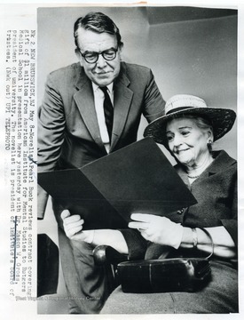 Caption reads, "New Brunswick, N. J. May 8 - Novelist Pearl Buck reviews contract covering gift of $1 million from American Institute for Mental Studies to Rutgers Medical School in presentation here yesterday with Dr. Mason W. Gross, president of university. The novelist is president of institute's board of trustees."