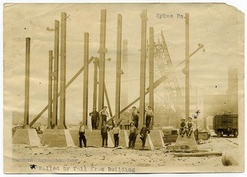 A group of workers poses at a building site. The man on the far right is marked as having been "killed by fall from building."
