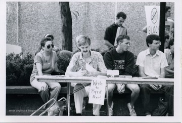 Chris Quesebarth and Meredith Pearce sitting at a stand during the Block Bork Protest.