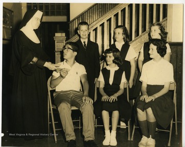 St. Francis Catholic School students handed slips by a nun.