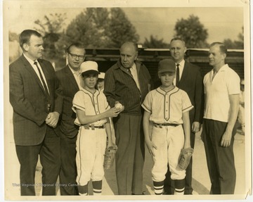 Mr. Wilson, owner of Wilson Chevrolet (2nd from left), and A. W. Buehler, mayor of Morgantown (4th of left), at the Morgantown baseball field with unidentified players and businessmen.