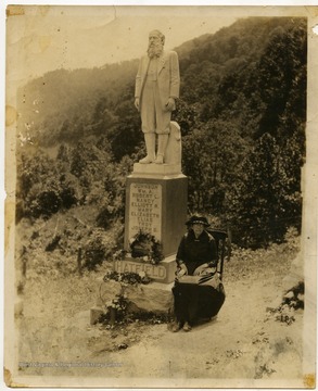 Levisa "Levicy" Hatfield family member sitting alongside the monument of her husband.
